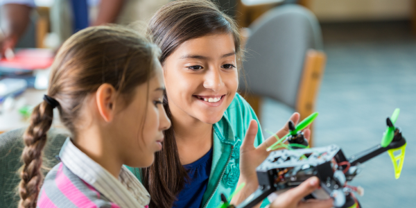 Planning After-School Activities - two girls learning to build a flying helicopter