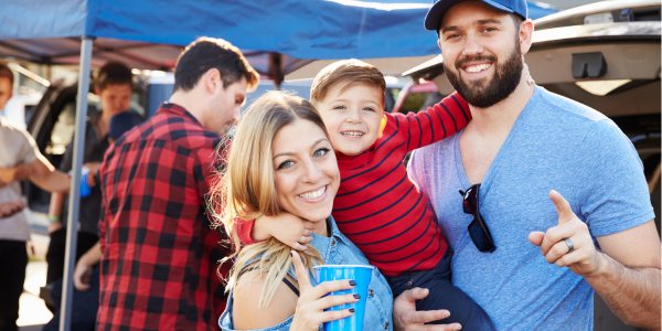 mom, dad, and toddler at football tailgate